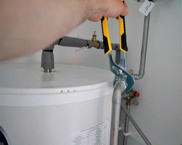 Plumber repairing water heater with professional tools